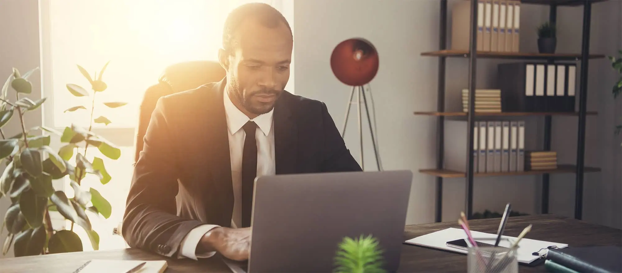 man looking at his laptop wearing suit